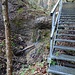 Eine erste Metalltreppe führt über eine Stufe hoch