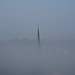 Der Versbacher Kirchturm schaut aus dem Nebel.