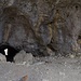 Im richtigen Winkel sieht man durch die Höhle perfekt zur anderen Öffnung. Und noch was. Rechts im Fels ist ein kleines Türchen. Dort würde der erfahrene Wanderer wohl sowas wie ein Höhlenbuch erwarten. Nicht so ein Hikr. Ein Hikr weiss, dass hinter diesem Türchen Höhlengeist steckt. 