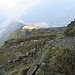 Nei pressi della cima, uno sguardo sui prati soleggiati della Capanna Brogoldone e sulla più lontana Bellinzona.