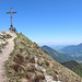 Geigelstein - Auf dem Gipfel des dritthöchsten Berges der Chiemgauer Alpen steht neben dem Kreuz auch eine kleine Kapelle. Für einen Augenblick hält sich der wochenend- und schönwetterbedingte Andrang in Grenzen.