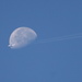 Moon going down and an airplane flying south