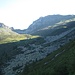 Tra sole ed ombra ecco comparire gli edifici dell’Alpe Borgna. La sella visibile in centro foto è rappresentata dalla Bocchetta di Cazzane, superata la quale si scende in Val Moleno; a destra invece, il Passo di Ruscada.