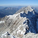 der Verbindungsgrat zur Sonntagskarspitze(T5+/II+); die verschneite, kleine Bergkuppe ist die Sonntagskarspitze(2575m), hinten der Doppelgipfel der Östlichen- und Westlichen Praxmarerkarspitze