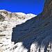 Una fascia rocciosa che si supera attraverso cengette ricoperte di detriti e qualche passo di arrampicata permette di metter piede nel catino superiore.<br />A destra si notano alcune persone.