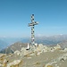 La croce del Corno Bussola, 3013 m. Vista verso ovest; a sinistra la piramide dell'Emilius, in fondo dietro la croce il Monte Bianco