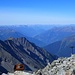 Blick vom Gipfel auf das tiefer liegende Gipfelkreuz, hinten stehen die Lienzer Dolomiten, ganz hinten die Südtiroler Dolomiten