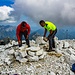 Zwei Bergsteiger haben sich die Mühe genommen um einige Steine zu stapeln, die als Gipfelmarkierung dient
