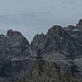 Man steht hier den Felsklötzen der Brenta unmittelbar gegenüber; wie fast immer, versteckt sich die Cima Tosa (3173 m) links hinter der Cima Brenta Alta (2960 m), dadurch wird die Szene von der etwas niedrigeren, aber wuchtigen Cima Brenta (3150 m) beherrscht. Links von ihr der Einschnitt Bocchetta bassa dei Massodi (2796 m), rechts davon ansatzweise die Bocca del Tuckett (2648 m). Vordergründig in Bildmitte, kaum auffallend die Cima Lasteri.