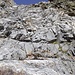 Die Kletterstelle oberhalb des rötlichen Vorsprungs (Schlüsselstelle). Das Gestein ist sehr fest und es gibt gute Griffe und Tritte.