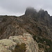 Punta di a Vacca - Ausblick am Gipfel in etwa nördliche Richtung, wo u. a. "Turm 4" (Punta di u Pargulu) von Wolken umgeben ist. Auch der weitere Verlauf der alpinen Variante des GR 20 ist zu erahnen.
