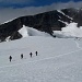 Ueber den flachen Gletscher geht's recht zuegig zu der Schneerampe, die hinten sichtbar ist. Dann in leichter Kletterei (I-II) zur flachen Gipfelabdachung.