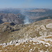 Maja e Rosit - Ausblick am Gipfel, u. a. nach Gusinje. Auch die Rauchwolke bei Vusanje ist zu erkennen sowie die Komovi (hinten links).
