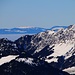 Chumigalm (2125,2m):<br /><br />Gipfelaussicht vorbei am Vanil d'Orseire (2012m) über die Hochnebeldecke des Mittellandes zum 77km entfernten Le Suchet (1588,0m). Der waadtländer Juragipfel lässt sich auf einer Wanderung gut mit der rechts daneben liegenden Aiguilles des Baulmes (1559m) kombinieren. Das Foto wurde mit stärkerem Zoom aufgenommen.<br /><br />Link zur stürmischen Winterwanderung auf beide Gipfel vom Januar 2010: [http://www.hikr.org/tour/post20083.html]