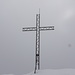 Gipfelkreuz in dichtem Nebel
