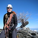 Tanja auf dem Fründenhorn 3369m. Dahiner ein Holzkreuz und ein Tannenbaum der seine Nadeln verloren hat.