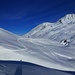 Rückblick, immer wieder kommen Skitourenfahrer von den Hügeln und laufen Richtung Hütte