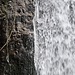 Eiszapfen hängen neben dem Wasserfall herunter