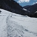Auf einem schneebedeckten Fahrweg geht es durch das Tal.