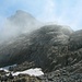 Der kleine Gipfel namens Sätteliteufi (2294m). Dahinter scheint der Gross Sättelistock (2637m) durch die Wolkenfetzen.