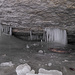 Stalaktiten und Stalagmiten aus Eis. Eingefrorenes Holz. Szenerie in der Glacière de Monlési.