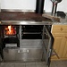 A sinistra la stufa a legna che serve per cucinare ed anche per scaldare l'acqua calda