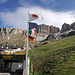 Start am Passo Pordoi - die Rinne wo's rauf geht, sieht man rechts der italienischen Flagge, der Gipfel ist rechts, aber nicht am Bild und die Station der Gondel ist rechts der europäischen Flagge