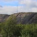 Kiruna existiert eigentlich nur wegen dem Eisenerzabbau. Am Hügel wurde im Tagbau bis 1962 im Tagbau abgebaut. Ab 1957 teilweise und ab 1962 wird das Eisenerz entlang der Erzader nur noch im Untertagbau gefördert. Bis 2018 wurde in 625m Tiefe gefördert, in Zukunft soll es noch Tiefergehen und Teile Kirunas sollen umgesiedelt werden, da die Wohnquartiere wegen Einsturzgefahr nicht sicher sein würden.<br /><br />Der Gipfel des Erzberges Kiirunavaara (auch Kirunavaara oder Kierunavaara) ist 733m hoch und noch natürlichen Ursprungs während die Flanken des eisenhaltigen Berges abgetragen wurden.