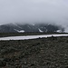 Als sich das Gelände oberhalb des breiten Rückens zurück legte, hätte ich eigentlich eine prächtige sicht auf den Kebnekaise gehabt. Doch die Gipfelregion versteckte sich leider in den Wolken. <br /><br />Nun musste ich als nächstes noch das Firnfeld überqueren um zur dahinter Moräne zu gelangen, dahinter folgt eine Gletscherquerung in Richtung der Felswand.