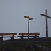 Die Gemeindschaft von zwei Sitzbänken, einem Wegweiser und einem Gipfelkreuz auf dem Gibel (2035,8m).