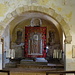 Innenraum der Kirche mit hangefertigtem Wandteppich