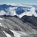 Man sieht im Vordergrund Gletscherschliffplatten, die der abgeschmolzene Gletscher freigegeben hat. Rechts des Schneebigen Nocks (ganz links) wären ohne Wolken Berge der Julischen Alpen zu sehen!