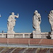 Petersdom (Basilica di San Pietro in Vaticano) - Über der Attika der Ost-Fassade sind dreizehn, etwa 6 Meter hohe Figuren aufgestellt. Mittig befindet sich Jesus, hier ganz links im Bild. Foto während des Abstiegs von der Kuppel bei einem Zwischenstopp im Dachbereich des Hauptschiffs (= verlängerter östlicher Kreuzarm).