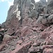 Weitere Aufstieg durch eine wilde rote Felslandschaft. Die weiter oben folgende Schlüsselstelle habe ich erst beim Abstieg im Rückblick fotografiert. Am vor mir gehenden korsischen Vater-und-Sohn-Paar erkennt man die Größenverhältnisse der riesigen Felsbrocken.