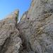18 An der Scharte haben wir angeseilt. Es geht die Rinne hinauf zum Einschnitt beim Turm (SG III+). Beim Kreuzchen beginnt der Enzensperger Kamin. Die gestrichelte Linie ist die Alternative zur Umgehung des Kamins (SG III+, Schlingenstände) 