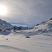 Blick gegen die Sonne in Richtung Flüelapass, am rechten Bildrand einige Skitüreler unterwegs zum Sentisch Horn.