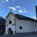 während des Starts in Isone: die Dorfkirche noch im Schatten - darüber jedoch einen schönen Bergtag verheissender blauer Himmel