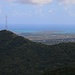 Mount Obama (402m): Gipfelaussicht im Zoom vorbei am Mc Nish Mountain (320m) über die gesamte Insel zur Nordostküste Antiguas mit der Halbinsel Guiana Island (wobei die Halbinsel eigentlich eine Insel, ist die nur durch wenige Dutzend Meter von der Hauptinsel abgetrennt ist).