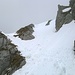 Nach der drahtseilversicherten Passage verläuft der finale Gipfelaufstieg über eine erste steilere Schneepassage in der Rinne links im Bild.