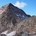 Blick vom namenlosen Aussichtspunkt zum Gipfel. Die Route führt oberhalb des Gletscherrestes über schmale Terrassen (weisse Strukturen im Bildvordergrund rechts) auf den Ostgrat.