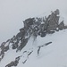 Inzwischen sind die Grate mit ihren Gipfeln wieder von Wolken verhüllt; rechts oben sieht man eine durch den Schnee bedingt anspruchsvolle Kletterstelle, die ich überwinden muss (II).