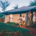 John Matte, Hüter des Mountain Club of Uganda, vor dem Büro des Clubs in Ibanda. Ein kleiner Teil seiner Familie ist anwesend.