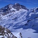 Blick vom Gipfel auf den schlecht eingeschneiten Roseggletscher vor Piz Bernina und Piz Roseg