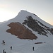 Eine Gruppe von Skitourengehern fährt von der Hütte ab.