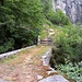 Eine Brücke über den Riale d'Iragna (749m).<br /><br />Der Weg führt dann weiter nach rechts unter der Felswand entlang nach Traversa (865m) <br />und noch weiter nach Pozzo (989m).<br /><br />Am Ende der Felswand, noch vor Traversa, <br />zweigt ein schlecht erkennbarer Weg nach rechts ab, <br />der direkt nach Pian Pönn (563m) hinunter führt. <br /><br />Dieser Weg ist zwar noch begehbar, aber in schlechtem Zustand. <br />Auf der online-Karte ist er noch bis zum Jahre 2005 eingezeichnet, dann nicht mehr. <br /><br />Als ich einmal von der Alpe Pianazzora nach Pozzo hinunterstieg,<br />bin ich auf einer eisigen Stelle ausgerutscht und voll auf die rechte Schulter gefallen.<br />Ich dachte, sei ausgerenkt. <br /><br />Ich erzähle das nur, weil mir so ein Sturz nicht passiert wäre,<br />wenn ich Mikrospikes an den Schuhen gehabt hätte.<br />Darum hier mein Tipp: Mikrospikes verwenden, wenn es eisig wird!<br /><br />In Pozzo hatte ich bemerkt, dass eine der Hütten bewohnt war.<br />Ich klopfte an, und der Mann, der die Türe öffnete, hat mir empfohlen, nicht den<br />normalen Weg von Pozzo nach Iragna hinunter zu nehmen, sondern den Weg von <br />Traversa nach Pian Pönn hinunter, das sei interessanter. So habe ich diesen Weg entdeckt.<br /><br />Nein, der Mann hat mir keinen heissen Kaffee offeriert, <br />was ich eigentlich insgeheim gehofft hatte, weil es schon Spätherbst<br />und gegen Abend war und ich kalt hatte ;-)<br /><br />Meine rechte Schulter war zwar beim Sturz nicht ausgerenkt worden, <br />aber sie war beschädigt. Nach 3 Jahren Physiotherapie war sie wieder<br />einigermassen gut. Sie macht mir heute beim Wandern keine Schwierigkeiten mehr,<br />aber auf der rechten Seite kann ich immer noch nicht schlafen. <br /><br />Okay, damit kann ich gut leben, ich schlafe sowieso nur wie eine Katze. <br /><br />Aber trotzdem, mein Tipp: Wenn es eisig ist, nicht so faul sein wie ich! Mikrospikes anschnallen!<br />