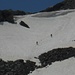 Hikers descending from Piz d'Emmat Dadaint by snow-surfing.