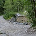 An der Dauerbaustelle am Straßenende. Links die Metallbrücke. Jenseits des Lainbachs stehen die Wanderschilder zur Tutzinger Hütte.