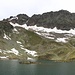 <b>Mutterberger See (2487 m).<br />Due isolotti emergono dal pelo dell’acqua. Qualcuno vi ha costruito degli ometti di pietra, molto probabilmente quando il lago era ancora coperto dalla neve.</b>