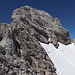 Im Abstieg vom Hohen Dachstein (via Schulteranstieg) - Rückblick. Vorn sind Teile des Klettersteiges zu erkennen, oben das Gipfelkreuz. In Originalgröße erahnt man auch, dass der Einstieg in den Randkluftsteig "rechts" der in den Gletscher reichenden Felsen erfolgt.