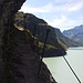 Oberhalb der zweiten Eisenleiter geht es luftig überm Lac de Mavoisin (1961m) auf den in den Fels gehauenen Querweg zum steilen Grasshang.